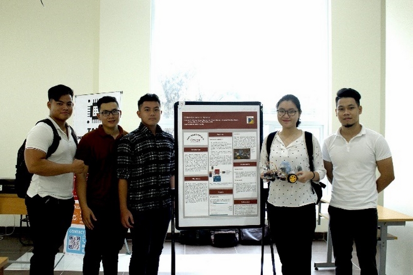A group of people standing next to a large poster

Description automatically generated with low confidence