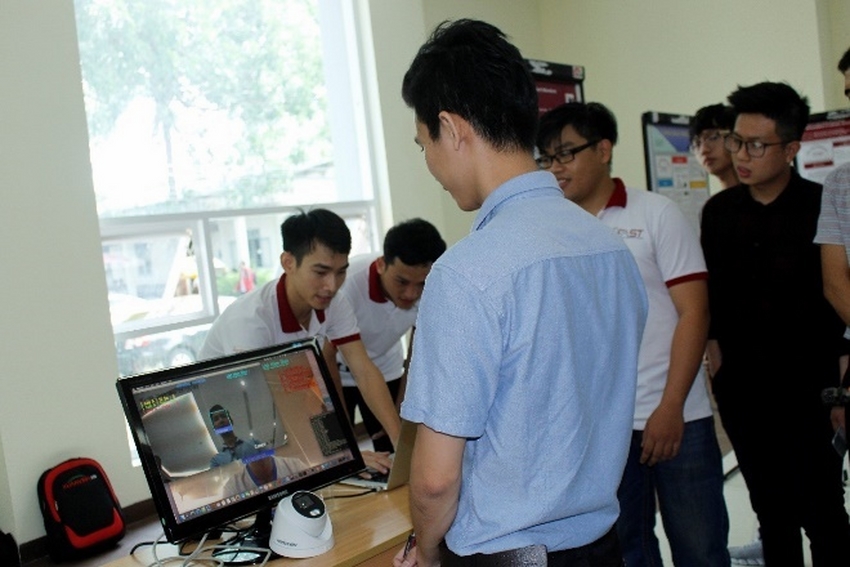 A group of people standing around a computer

Description automatically generated with medium confidence