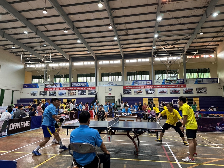 A group of people playing ping pong in a gymnasium

Description automatically generated with medium confidence