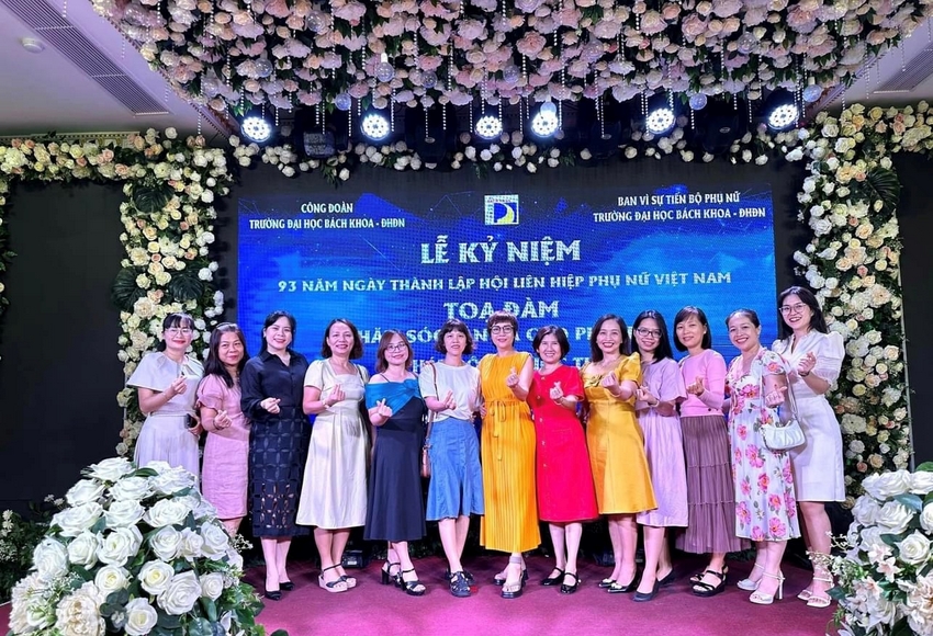 A group of women standing together in front of a stage with flowers

Description automatically generated