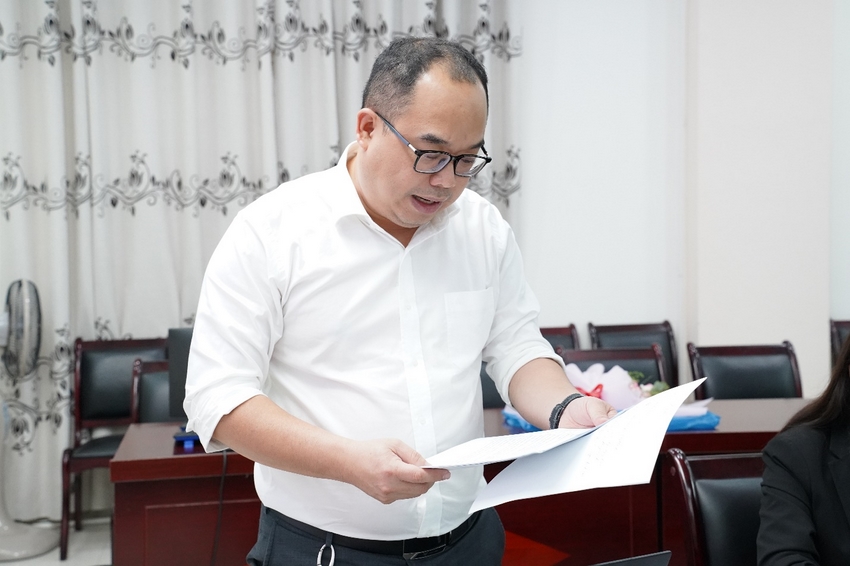 A person reading a piece of paper
Description automatically generated