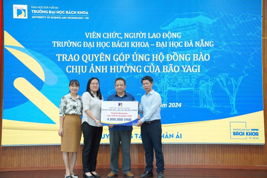 A group of people standing in front of a large sign

Description automatically generated