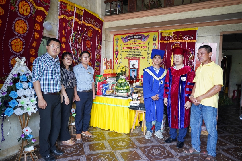 A group of people standing in front of a table with a statue
Description automatically generated with low confidence