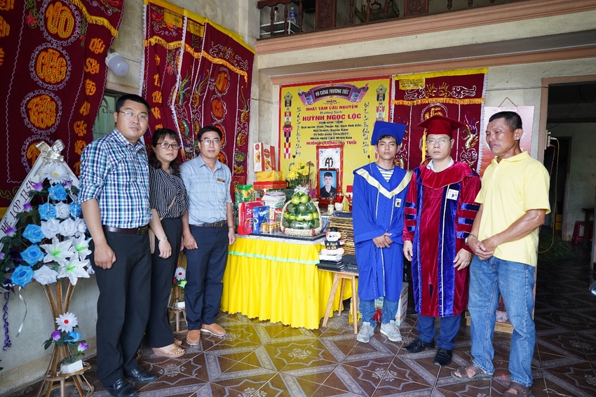 A group of people standing in front of a table with a statue

Description automatically generated with low confidence