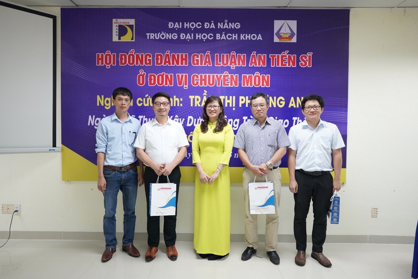 A group of people standing in front of a banner
Description automatically generated
