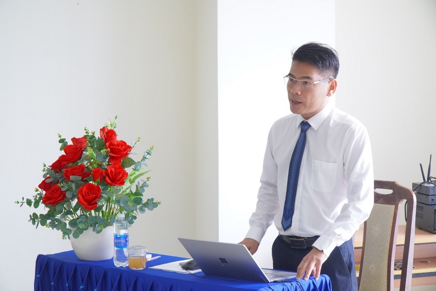 A person standing next to a table with a computer

Description automatically generated