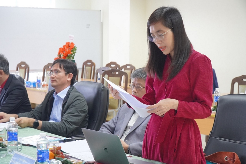 A person in a red dress reading a paper

Description automatically generated