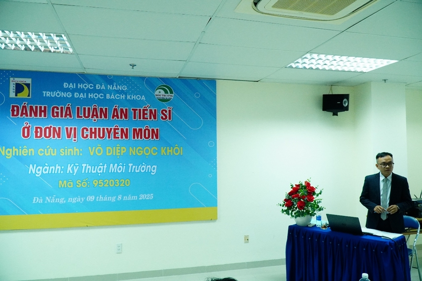 A person sitting at a table in front of a sign

AI-generated content may be incorrect.