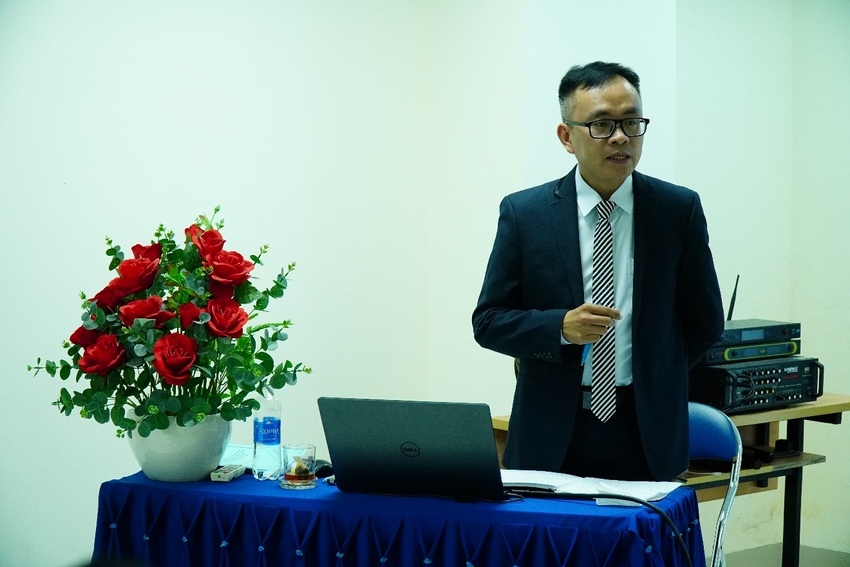 A person in a suit and tie standing next to a table with a computer and flowers

AI-generated content may be incorrect.