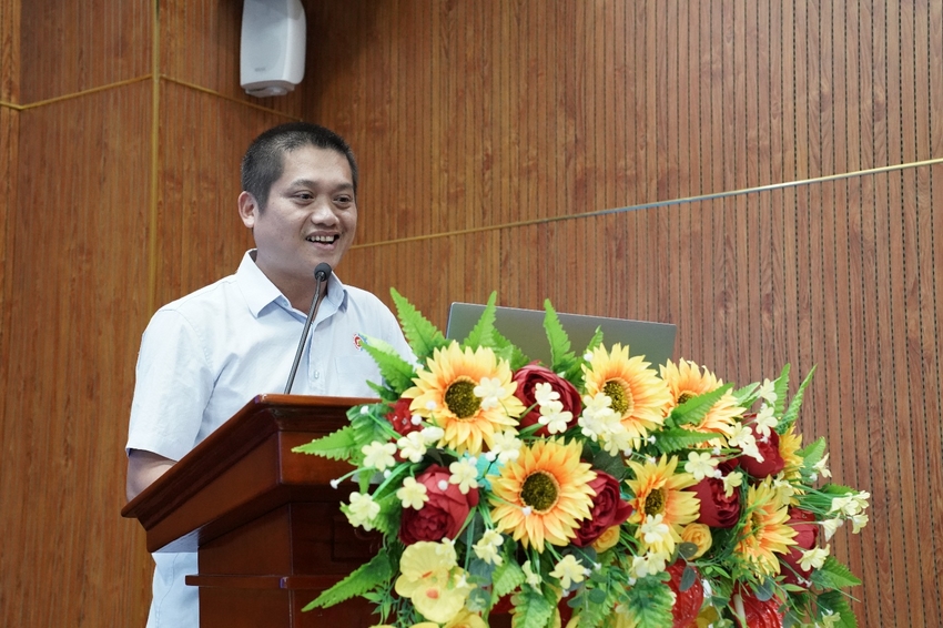 A person standing at a podium with a microphone and flowers

AI-generated content may be incorrect.