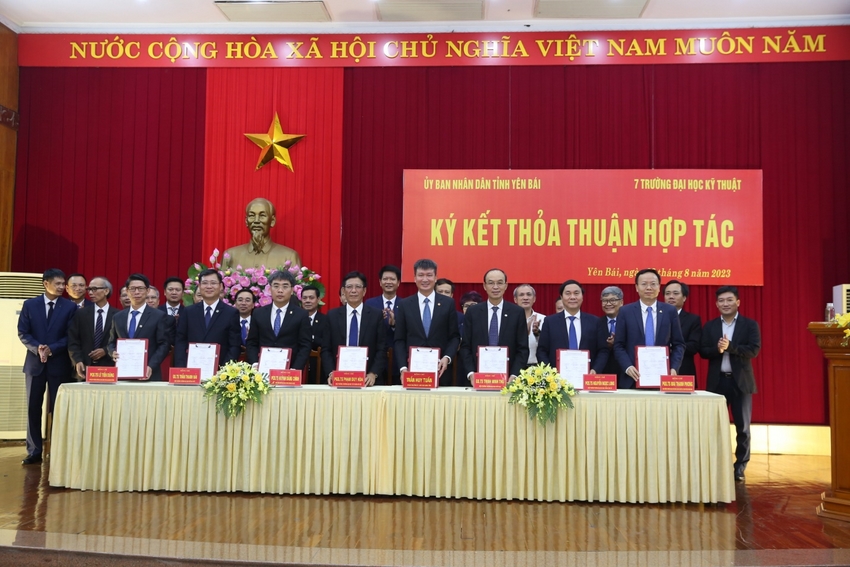 A group of people standing in front of a red banner

Description automatically generated