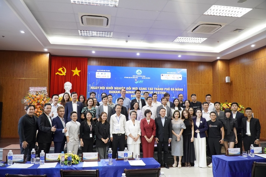 A group of people standing in front of a blue table

Description automatically generated