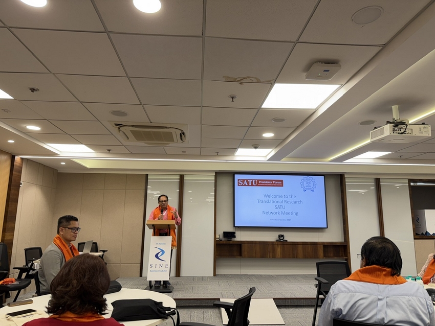 A person standing in front of a podium with a screen on the wall

AI-generated content may be incorrect.