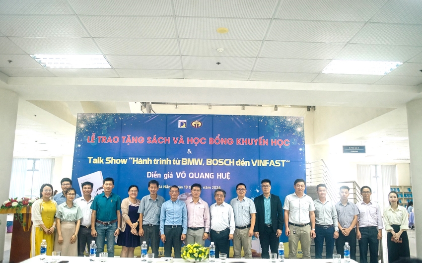 A group of people standing in front of a banner

Description automatically generated