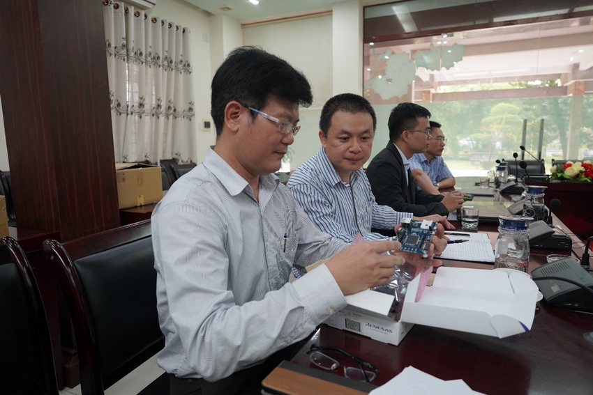 A group of men sitting at a table looking at a paper
Description automatically generated with low confidence