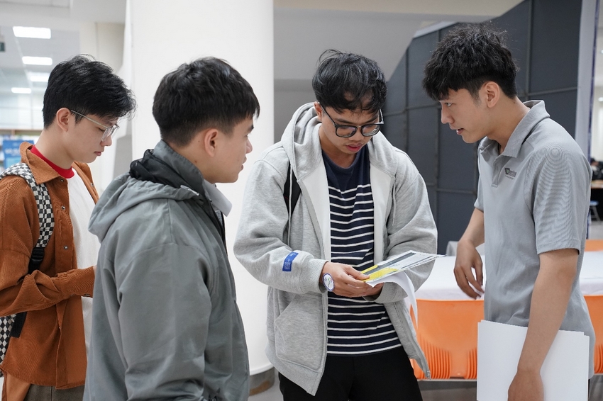 A group of young men looking at a piece of paper

Description automatically generated