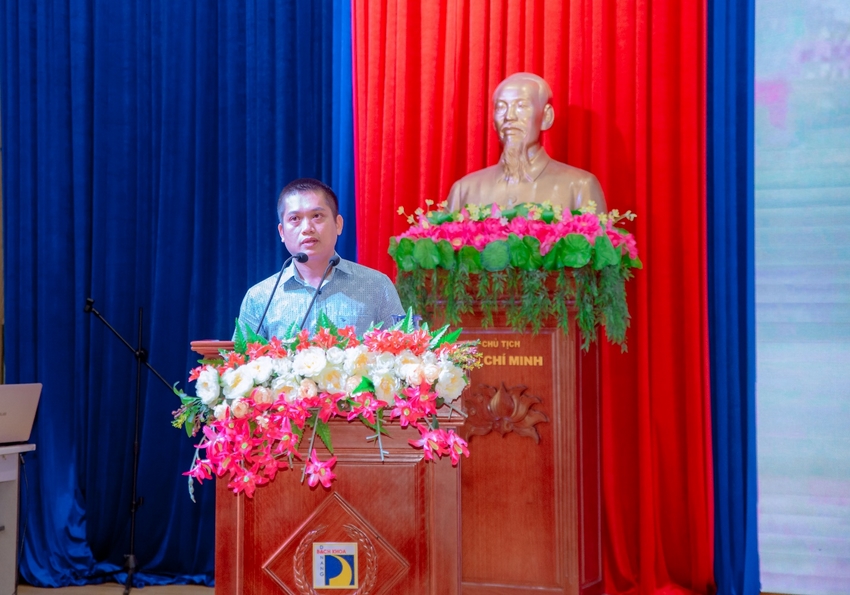 A person standing behind a podium with flowers in front of a statue

Description automatically generated with medium confidence