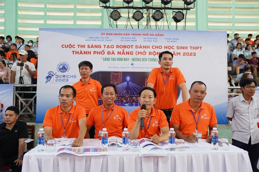 A group of men in orange shirts

Description automatically generated