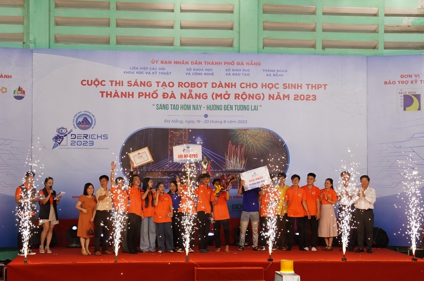 A group of people standing on a stage with fireworks
Description automatically generated