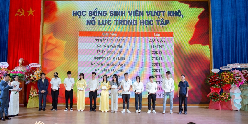 A group of people standing in front of a large screen

Description automatically generated