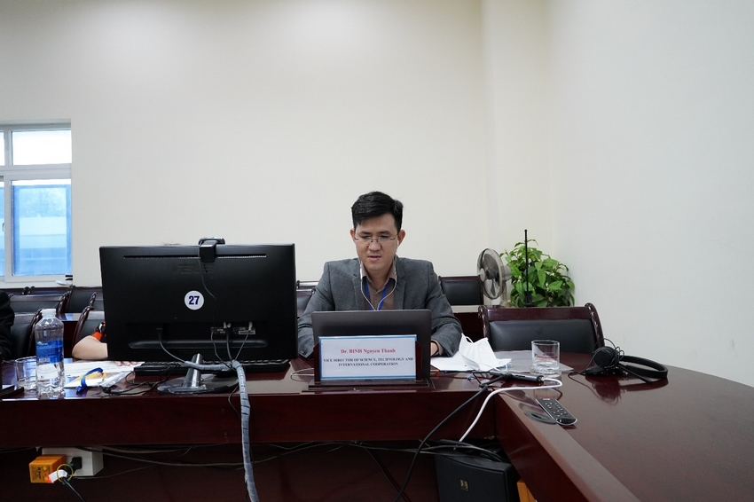 A person sitting at a desk with a computer and other objects
Description automatically generated with low confidence