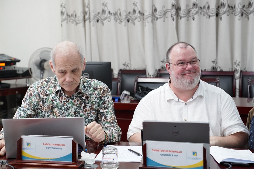 Men sitting at a table looking at laptops

Description automatically generated