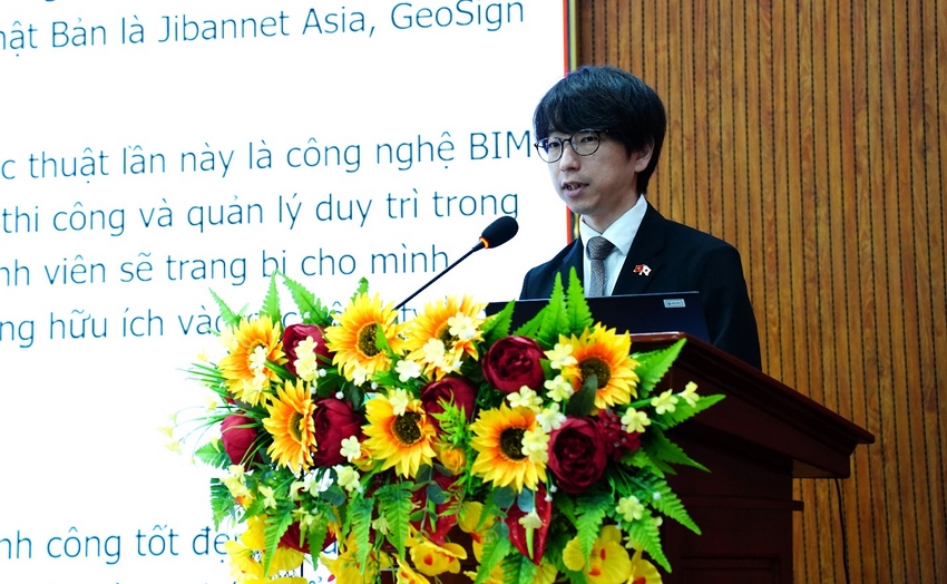 A person standing at a podium with a microphone and flowers

AI-generated content may be incorrect.