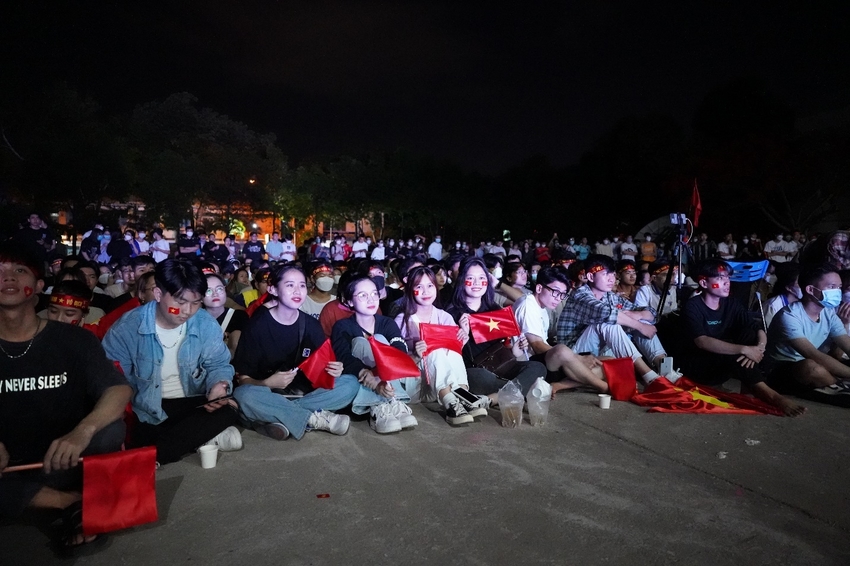 A large crowd of people sitting on the ground at night

Description automatically generated with medium confidence