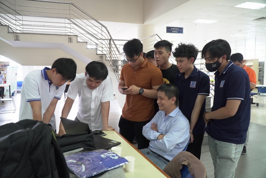 A group of people standing around a table
Description automatically generated with low confidence